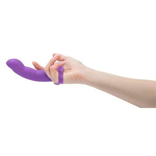 A hand wears the Simple and True Purple Silicone G-Spot Finger Extender, a silicone finger vibrator designed for fingering pleasure, against a plain white background.
