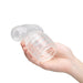 A hand holds the Slider Clear Male Masturbator Wand Attachment—a transparent, textured cylindrical sleeve with a T-shaped bend—against a plain white background.