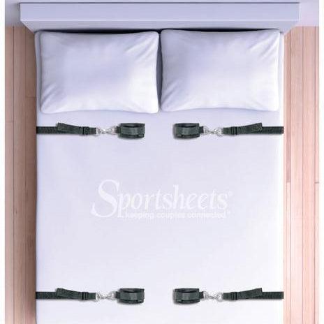 The Sportsheets Under the Bed Restraint System is a discreet bondage accessory featuring a plain white bed design with black corner straps, displaying the sleek "Sportsheets, Keeping couples connected" logo and slogan. It's ideal for securely holding hands and feet in place in a bondage bedroom.