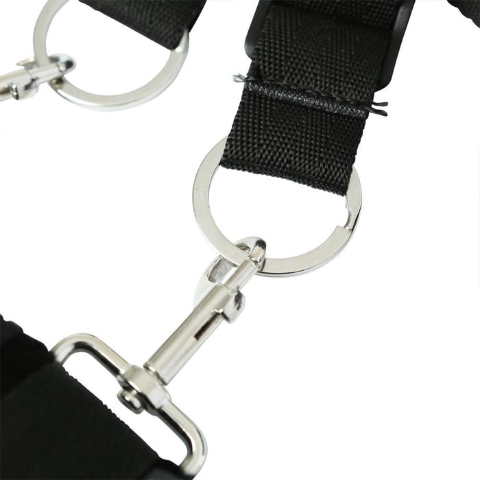 A close-up of a black strap with silver rings and clips, the durable and adjustable Sportsheets Under the Bed Restraint System is perfect for bondage setups, designed for secure fastening and easy attachment to additional gear or equipment.