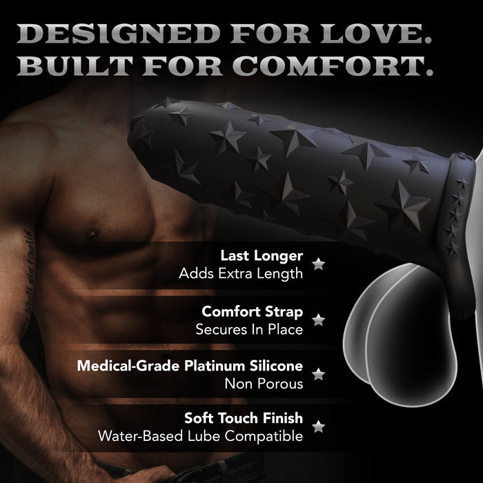 A muscular shirtless man poses by the Star Studded Silicone Penis Extender - 6.5 Inch Closed Ended in black with star designs. Bold text: "DESIGNED FOR LOVE. BUILT FOR COMFORT." Features: extra length, comfort strap, platinum silicone, soft touch finish.