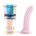 A pink glitter Starlight Smooth 7 Inch Silicone Dildo with suction cup stands upright beside its iridescent “Dildolls Starlight” packaging, a pastel box by Love to Love featuring small icons and showcasing the playful liquid silicone toy.