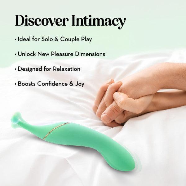 The Stella Double Ended G-Spot & Clitoral Vibrator, shown in green on a bed by clasped hands, is perfect for solo or couple play, unlocking new pleasure dimensions while promoting relaxation, confidence, and joy.