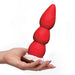 A hand with glittery red manicured nails holds the Strawberry Sweet Cream 8 Inch Silicone Dildo with Suction Cup—red, three-segmented, cone-shaped with a brown base and white edging, crafted from premium silicone.