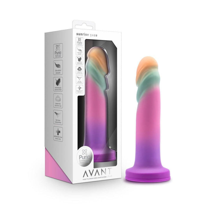 The Sunrise Gaze Textured Silicone Suction Cup 7.5 Inch Dildo, shown upright in a colorful gradient with its box, is harness compatible, designed for g-spot stimulation, and features highlighted on the Avant packaging.