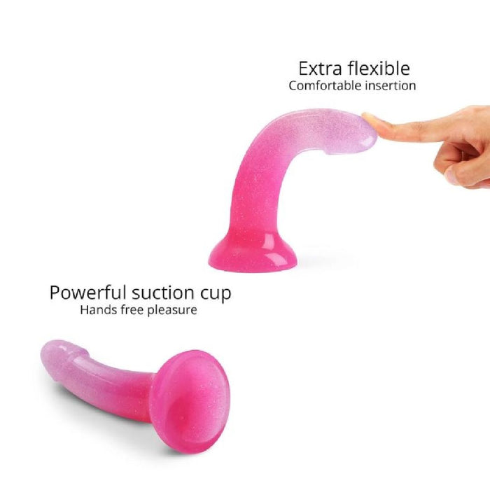A hand bends the Sunrise Smooth 7 Inch Pink Ombre Glitter Silicone Dildo with Suction Cup, showing off its extra flexibility for comfortable insertion, perfect for prostate or g-spot play, and a strong suction base for hands-free fun.
