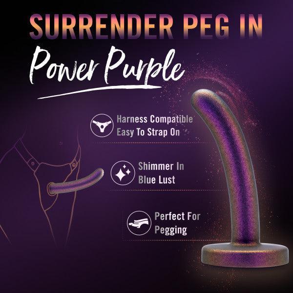 A metallic purple Surrender Small 4.75 Inch Silicone Dildo stands upright. Features include "Harness Compatible," "Easy To Strap On," and a shimmering finish—perfect for beginner dildo play and pegging.