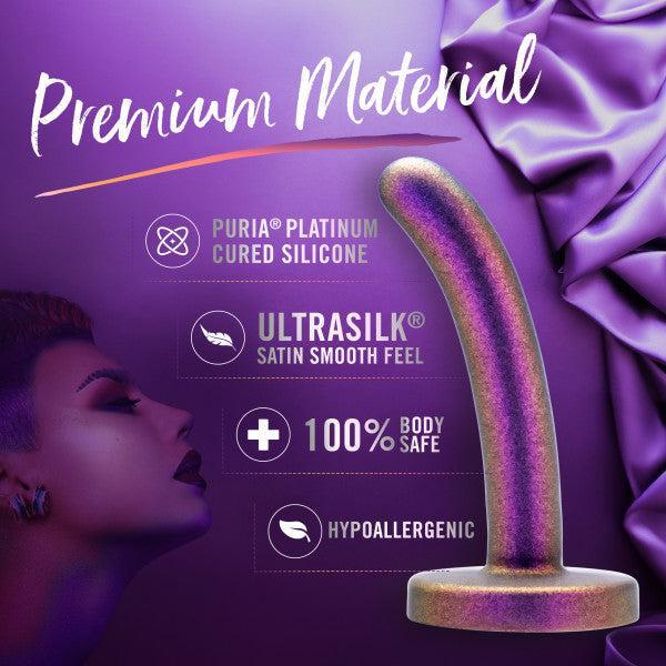The Surrender Small 4.75 Inch Purple Silicone Beginner & Pegging Dildo is shown on purple satin. Made of premium Puria Platinum Cured Silicone, it's ultrasmooth, 100% body safe, hypoallergenic—ideal for pegging or beginner dildo play.