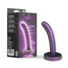 A glittery, curved Surrender Small 4.75 Inch Purple Silicone Beginner & Pegging Dildo stands upright by its "Temptasia" packaging with product details and purple accents—ideal for adventurous beginners or pegging play.