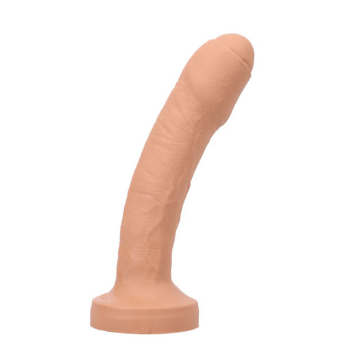 The Tantus Uncut Dual Density Silicone 9 Inch Dildo in Vanilla features an ultra-realistic uncircumcised design, veined texture, curved shaft, and flat suction base, standing upright against a white background.