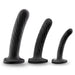 The Temptasia Twist Set of 3 Curved Black Silicone Pegging Dildos, spiral-textured and body-safe with flared bases, are lined up in ascending size from right to left for safe and satisfying G-spot stimulation.