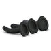 The Temptasia Twist Set features 3 black silicone pegging dildos with curved, spiral stems and heart-shaped bases, arranged in a row on a white background—each a different size for customized G-spot stimulation.