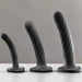The Temptasia Twist Set of 3 Curved Black Silicone Pegging Dildos features textured, twisted designs for G-spot stimulation in three sizes. Made from body-safe silicone, they stand upright on a white surface against a gray background.