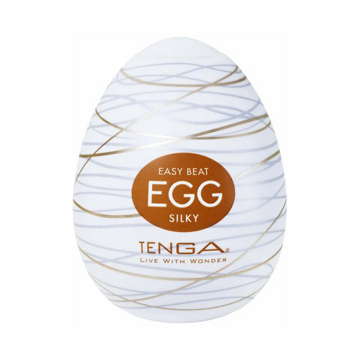 The Tenga Egg Disposable Penis Masturbator - Silky is an egg-shaped white toy with gold swirls and a brown label. Branded "TENGA" with "LIVE WITH WONDER," it’s a perfect disposable travel masturbation sleeve.