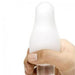 A hand holds a white, rounded object with a bulbous top, resembling the Tenga Egg Disposable Penis Masturbator - Starry, a popular innovative travel sex toy.