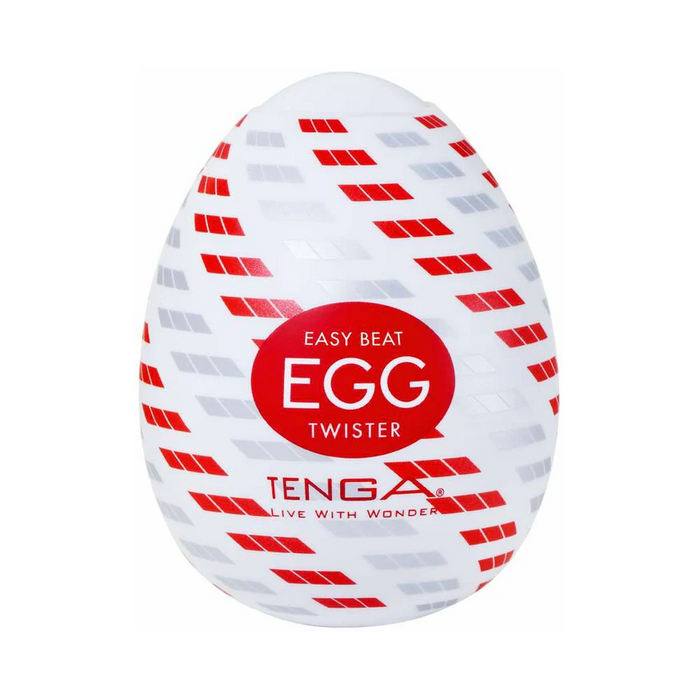 The Tenga Egg Disposable Penis Masturbator - Twister is a compact, white, egg-shaped travel sex toy with red and gray diagonal patterns and "Easy Beat Egg Twister" plus "TENGA Live with Wonder" on a red circle in the center.