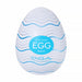 A white, egg-shaped male masturbator with wavy blue lines, featuring a textured sleeve for heightened pleasure. Sold as the "Tenga Egg Standard 3 Pack Disposable Masturbators I," with branding on the front.