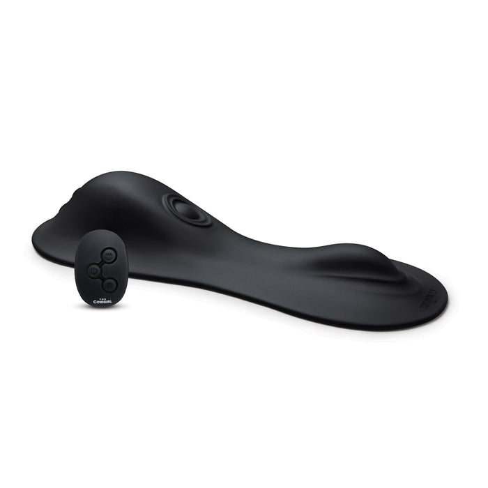 The Cowgirl Rodeo Rumbler Grinding Sex Machine features a black, contoured ergonomic pad for hands-free use, shown with a compact oval remote control featuring three buttons.
