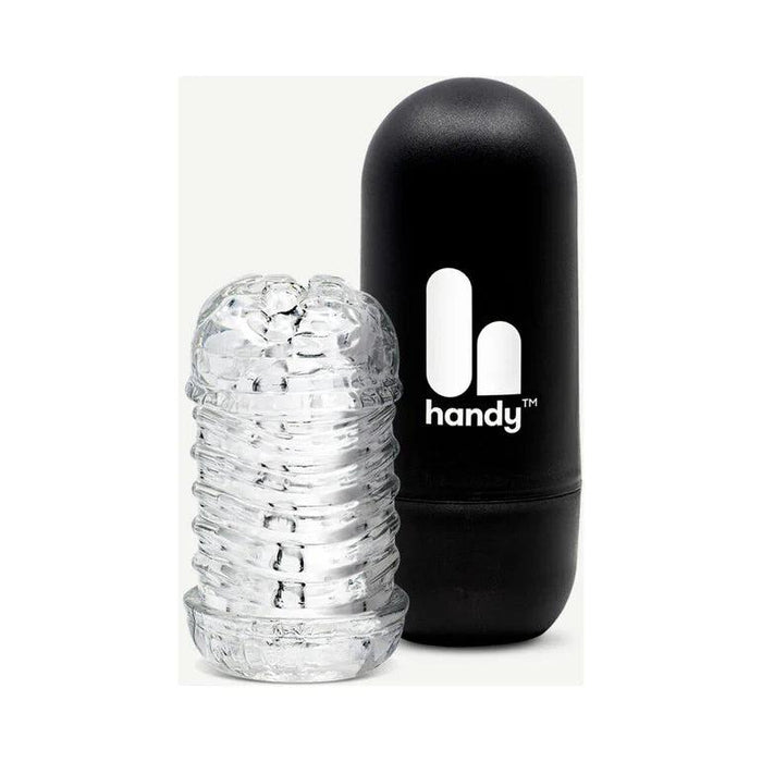 The Handy Dream Collection Touch Sleeve, a transparent textured cylinder for targeted stimulation, is displayed beside a black capsule-shaped case marked "handy" with a white logo.