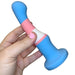 A hand with pink-painted nails holds the Trans Pride Slim Curved 6 Inch Silicone Suction Cup Dildo, crafted from platinum-cured silicone with blue, pink, and white stripes inspired by the transgender pride flag.