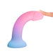 A person's finger gently touches the Utopia Sleek 7 Inch Pink and Blue Ombre Silicone Dildo with Suction Cup, featuring a blue-to-pink gradient design, against a white background.