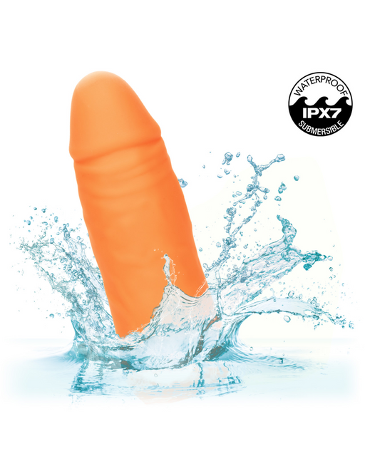 An orange, phallic-shaped silicone device splashing in water. The image includes a "Waterproof IPX7 Submersible" badge in the top right corner. Crafted from body safe silicone, the CalExotics Vibrating Stud Mini Cock Shaped Bullet Vibrator - Orange promises an invigorating experience.
