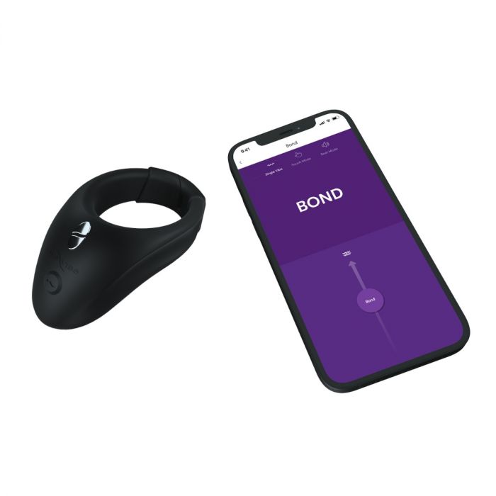 The We-Vibe Bond Vibrating App Controlled Couples Ring is displayed beside a smartphone featuring the We-Vibe app’s purple screen, "BOND" label, and a slider control for customizable vibrations.