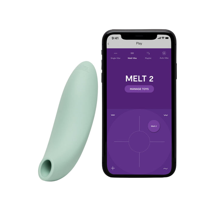 A mint green We-Vibe Melt 2 Rechargeable Pleasure Air Clitoral Stimulator is shown beside a smartphone with the Melt 2 app interface on a purple background, displaying controls for managing pleasure air clitoral stimulation.