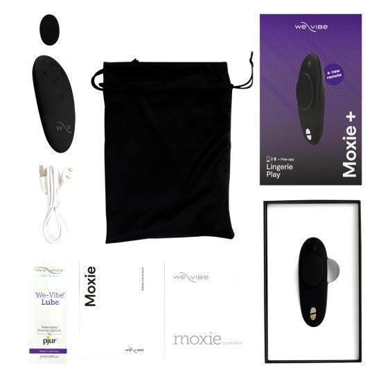 The We-Vibe Moxie+ Hands-Free Remote or App Controlled Panty Vibrator set includes a black vibrator with magnetic clip, remote control, USB charging cable, black pouch, manuals, lubricant sample, and packaging.