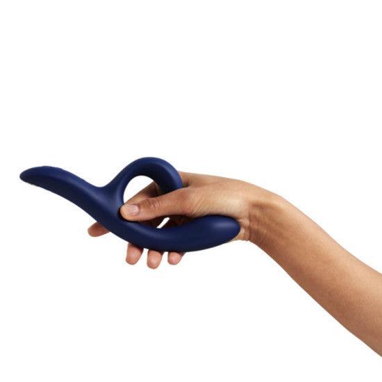 A hand holds the We-Vibe Nova 2 Powerful Flexible G-Spot Rabbit Vibrator, a blue silicone device with a curved design and looped handle, against a plain white background.