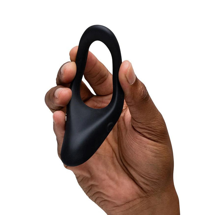 Hand holding a smooth, black silicone We-Vibe Verge 2 vibrating cock ring with a flexible, ergonomic design.