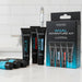 Four black tubes from the Wicked Anal Adventure Variety Pack—containing 4 travel-sized anal lubricants—stand by their box on a white countertop, with extra lubricant tubes in front and a white tiled wall as the backdrop.