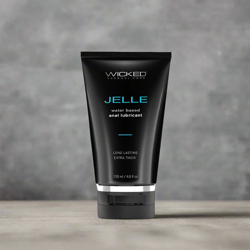 A black cylindrical tube labeled "Wicked Anal Jelle Water Based Lubricant 4 oz" by Wicked Lubes stands upright against a white background. The packaging also states "Long Lasting Extra Thick" and confirms that this 120 ml (4.0 fl oz) product is sex toy friendly.