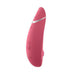 The Womanizer Premium 2 Pleasure Air Clitoral Stimulator, a pink device with a curved shape, multiple buttons, and a silver accent near the top, is photographed on a white background.