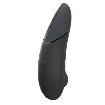 A sleek black handheld device with a curved design, front buttons, and a top power indicator—this is the Womanizer x We-Vibe Lust & Luxury Collection, featuring innovative Pleasure Air technology.