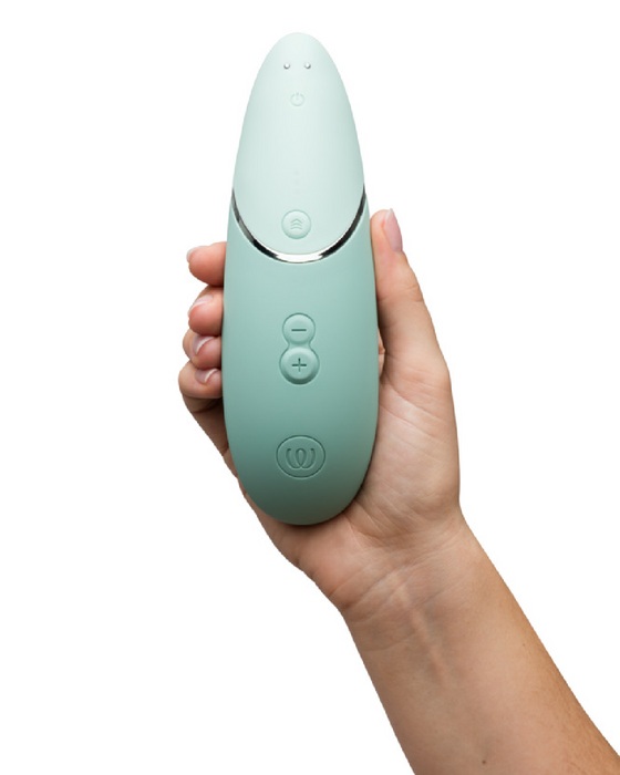 Womanizer Next  Pleasure Air Clitoral Vibrator - Sage Green upright in model's hand 