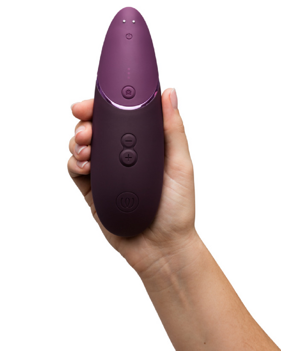 Womanizer Next  Pleasure Air Clitoral Vibrator - Plum in models's hand 