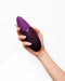 Womanizer Next  Pleasure Air Clitoral Vibrator - Plum held on angle in model's hand 