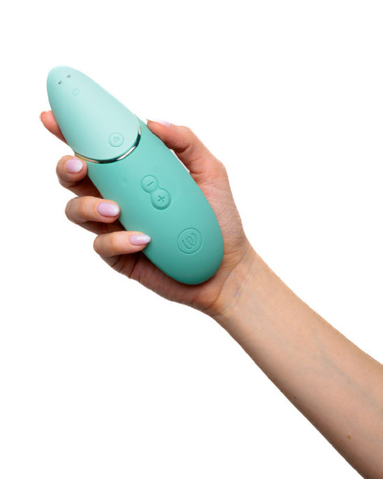 Womanizer Next  Pleasure Air Clitoral Vibrator - Sage Green on angle in hand 