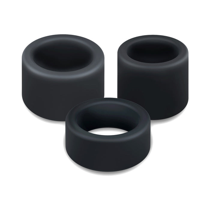 Three black silicone cock rings from the Accelerate Thick Stretchy Cock Rings Set of 3, each wide-holed and cylindrical, are arranged closely together on a white background.