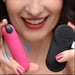 A smiling woman with pink nails and red lipstick holds the BANG! Vibrating Bullet with Remote Control, both featuring power buttons; blue lines illustrate vibration.