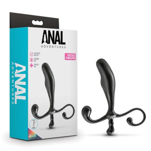 Image of a boxed product labeled "Anal Adventures Prostate Stimulator - Black" by Blush. The packaging showcases a black prostate massager with two curled handles at the base, made from premium silicone. The product is displayed both inside the packaging and next to it, emphasizing its waterproof design and distinctive features.