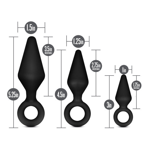 Image of Blush's Anal Adventures Silicone Loop Anal Training Butt Plug Set, featuring three black body-safe silicone anal plugs with ring handles at the base. From left to right: the largest plug is 5.25 inches long with a 1.5-inch width, the medium plug is 4.5 inches long with a 1.25-inch width, and the smallest black tapered plug is 3 inches long with a 1-inch width.
