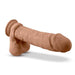 Introducing the Au Naturel 9.5 Inch Dual Density Suction Cup Dildo in Mocha by Blush. Crafted to resemble a human penis, this realistic, flesh-toned silicone toy features an attached scrotum base and a robust suction cup for versatile use, all showcased horizontally against a white background.
