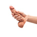 A person holding the b-Vibe Slipskin Realistic 6 Inch Girthy Silicone Dildo in Caramel, prepared with a large condom.