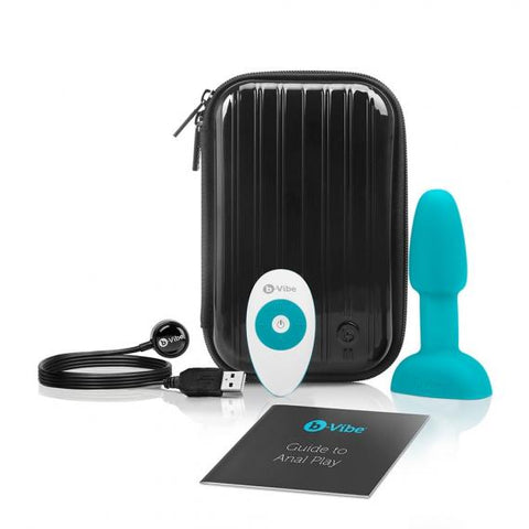A B-Vibe Rimming Butt Plug Petite with Remote Control - Various Colors set including a dark case, a blue body-safe silicone rimming plug, a white wireless remote control, a USB cable, and an instruction booklet, displayed against a white background.