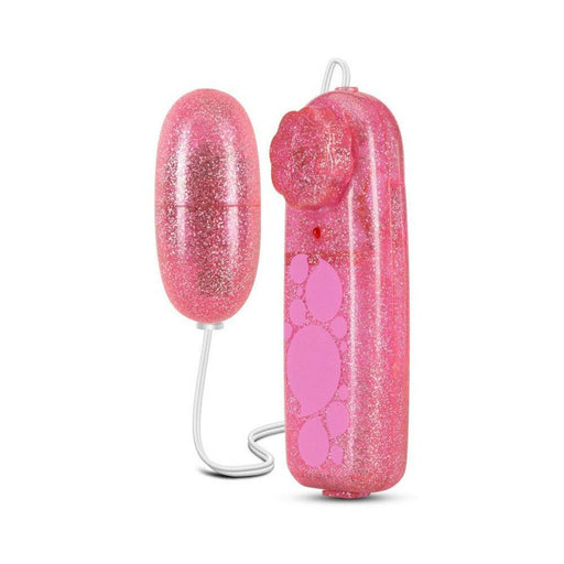Introducing the B Yours First Time Wired Remote Control Bullet Vibrator by Blush in pink, featuring a glittery remote with several circular buttons and a small indicator light. This multispeed device is designed for clitoral stimulation with a connected egg-shaped component, seamlessly linked to the wired remote.