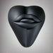 The Bananapants Kissi Dildo Base features a black, sculptural heart shape with abstract lips and tongue on its surface. Crafted from body-safe silicone, it's shown against a white background.