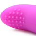 Close-up of the tip of a purple, remote-controlled bullet vibrator from the BANG! Couple's Cock Ring, Finger Vibe, Bullet & Blindfold Kit by XR Brands. The tip features small, raised dots in a pattern at the end, with a smooth surface except for the textured area with the dots. The object appears to be part of a personal care item or intimate device set.