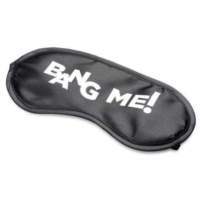 A purple sleep mask with white text in a bold font that reads "BANG ME!", ideal for pairing with the products in the BANG! Couple's Cock Ring, Finger Vibe, Bullet & Blindfold Kit by XR Brands to enhance your experience.